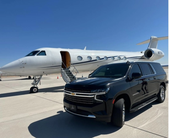 A luxury black SUV at airport in-front of a white private jet